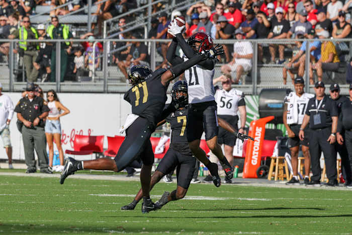 Oct 29, 2022; Orlando, Florida, USA; Cincinnati Bearcats wide receiver Tyler Scott (21) catches a pass as UCF Knights linebacker Jeremiah Jean-Baptiste (11) and cornerback Davonte Brown (7) move in during the second quarter at FBC Mortgage Stadium. Mandatory Credit: Mike Watters-USA TODAY Sports